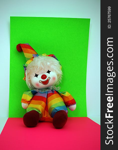 Rainbow Colored Happy Smiling Clown Doll on Bright green, red and blue Background. Rainbow Colored Happy Smiling Clown Doll on Bright green, red and blue Background