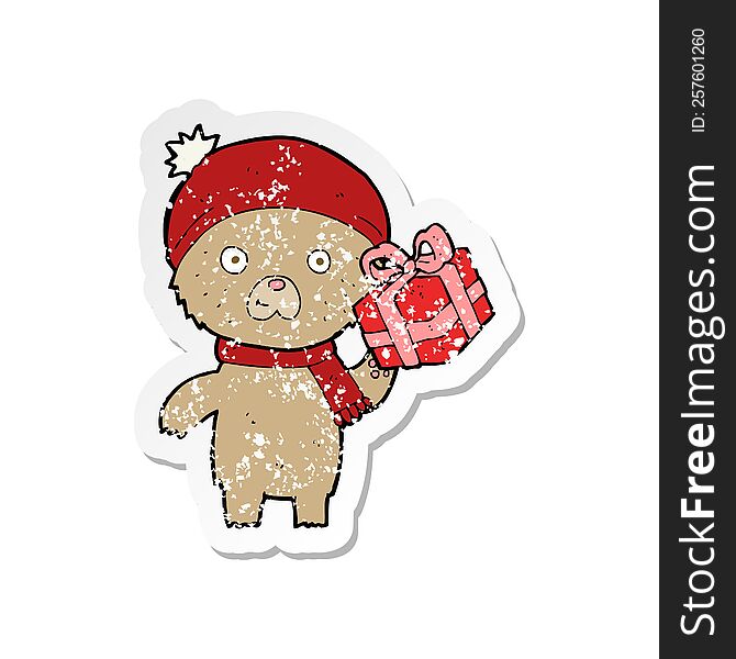 retro distressed sticker of a cartoon christmas teddy bear with present