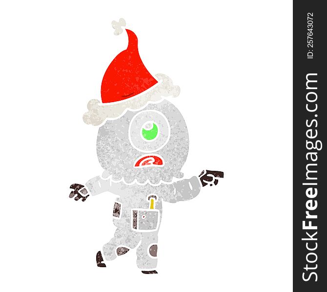 Retro Cartoon Of A Cyclops Alien Spaceman Pointing Wearing Santa Hat