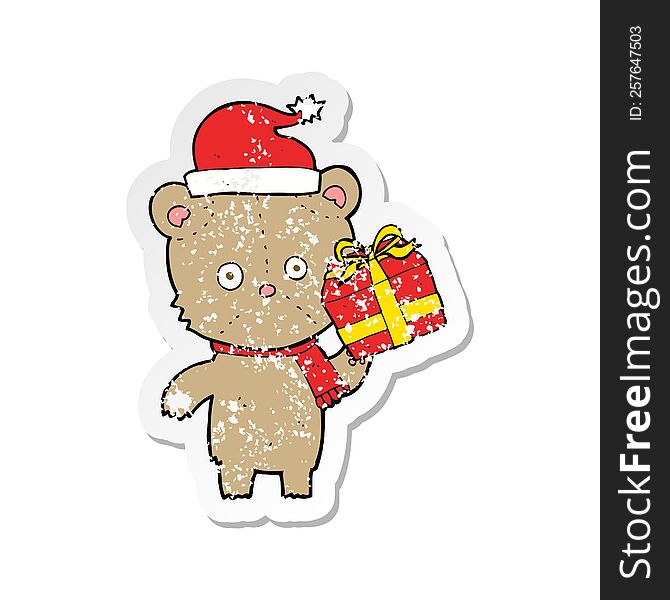 retro distressed sticker of a cartoon christmas teddy bear with present