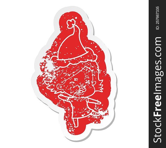 cartoon distressed sticker of a girl pulling face wearing santa hat