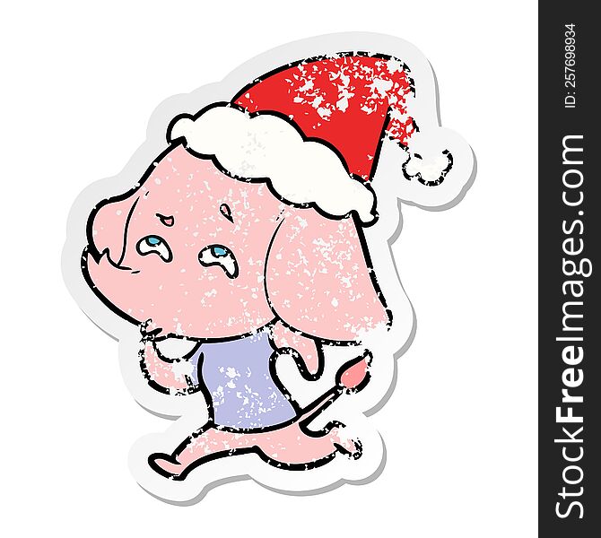 hand drawn distressed sticker cartoon of a elephant remembering wearing santa hat