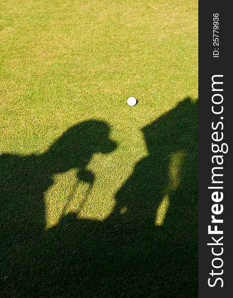 Silhouette of a golfer putting his golf clubs back in this bag in the golf cart