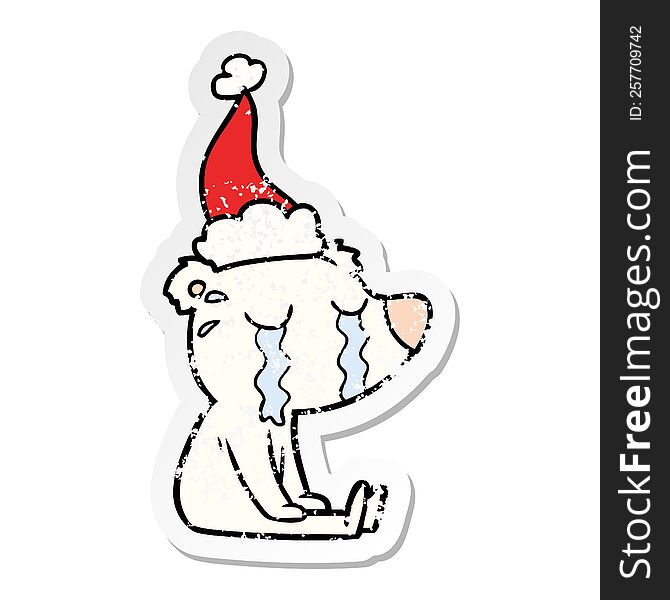 hand drawn distressed sticker cartoon of a crying sitting polar bear wearing santa hat