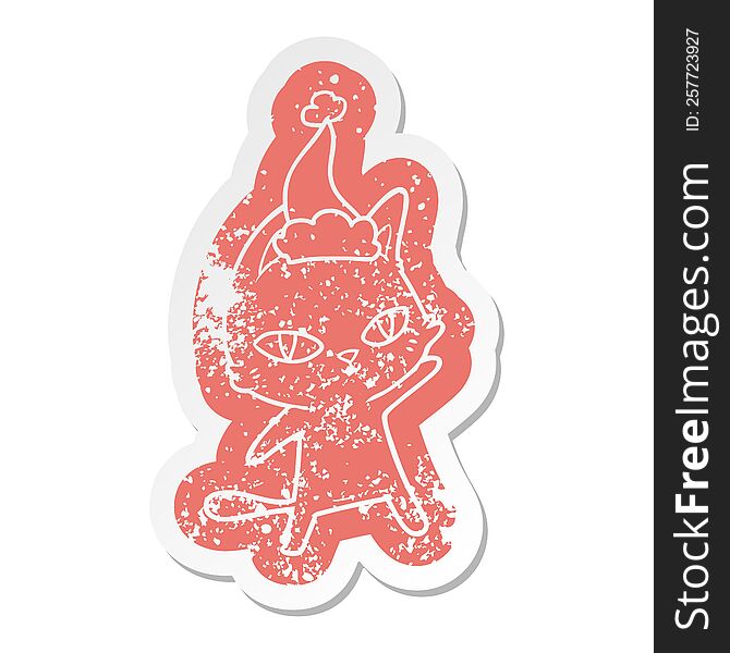 quirky cartoon distressed sticker of a cat staring wearing santa hat