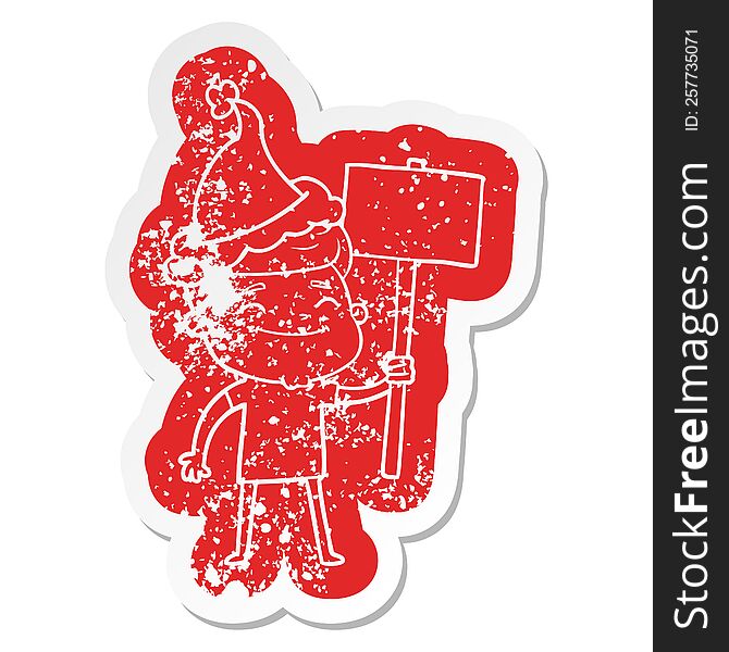 Happy Cartoon Distressed Sticker Of A Man With Placard Wearing Santa Hat