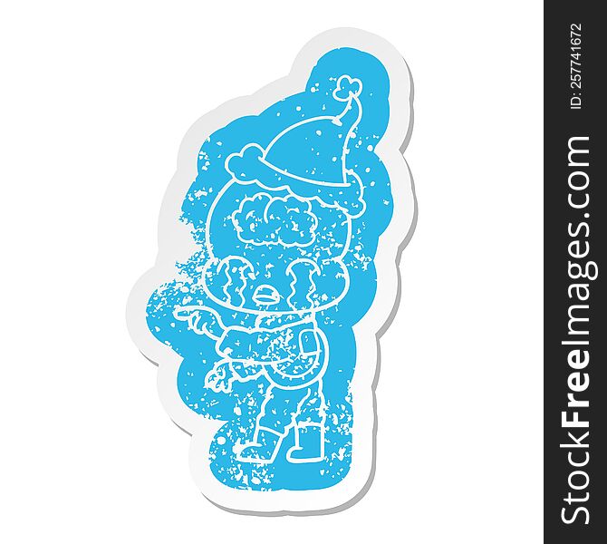 Cartoon Distressed Sticker Of A Big Brain Alien Crying And Pointing Wearing Santa Hat