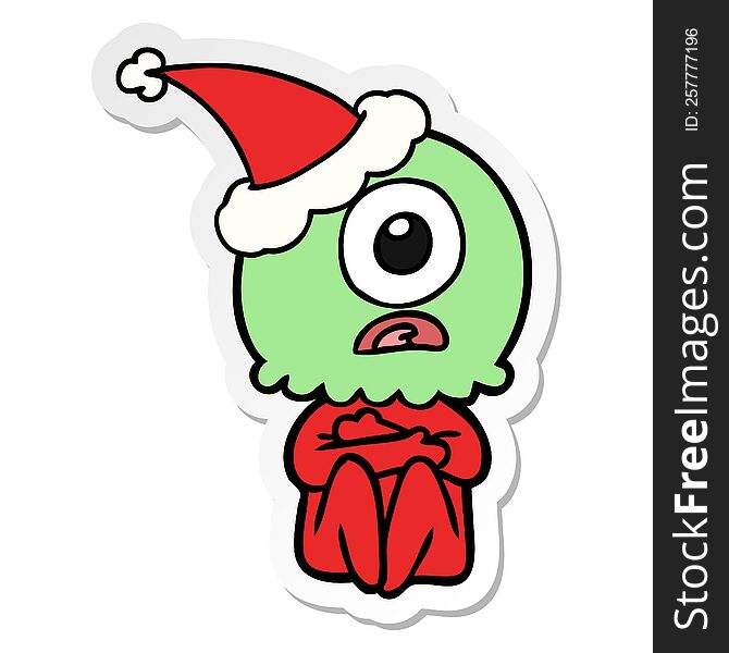 hand drawn sticker cartoon of a cyclops alien spaceman wearing santa hat