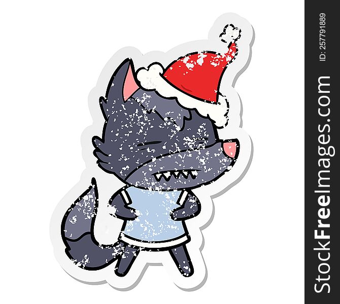 hand drawn distressed sticker cartoon of a wolf showing teeth wearing santa hat