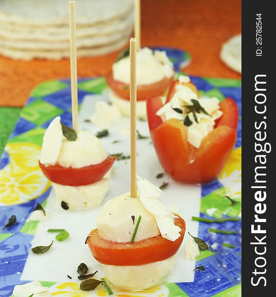 Cheese skewers with tomatoes seasoned with olive oil and oregano leaves