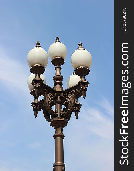 Old streetlight in the blue sky background. Old streetlight in the blue sky background