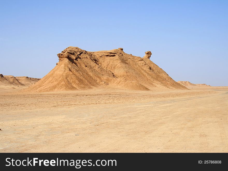 The photo of sandy mountain in the form of a camel against blue sky. The photo of sandy mountain in the form of a camel against blue sky