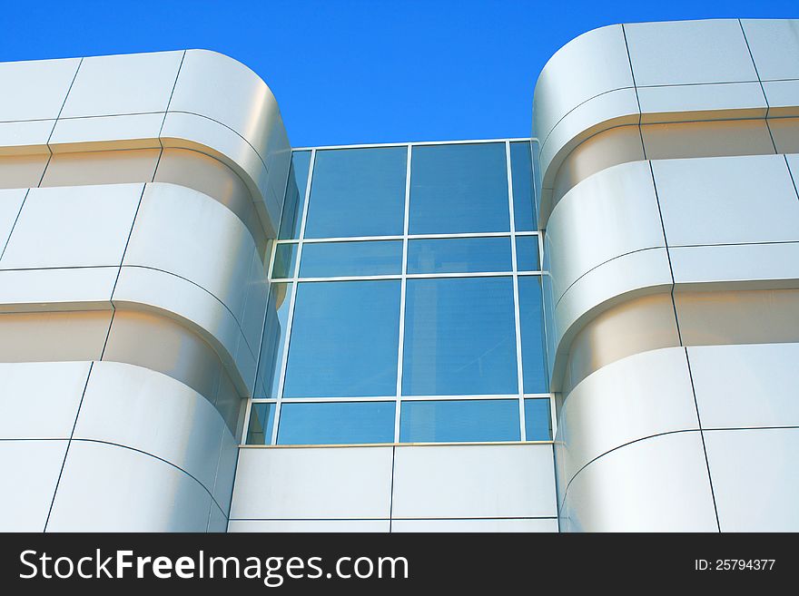 The photo of big modern building from glass and iron against blue sky