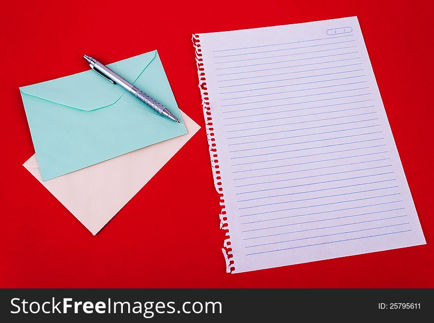 Envelope of correspondence, pen and blank notebook sheet