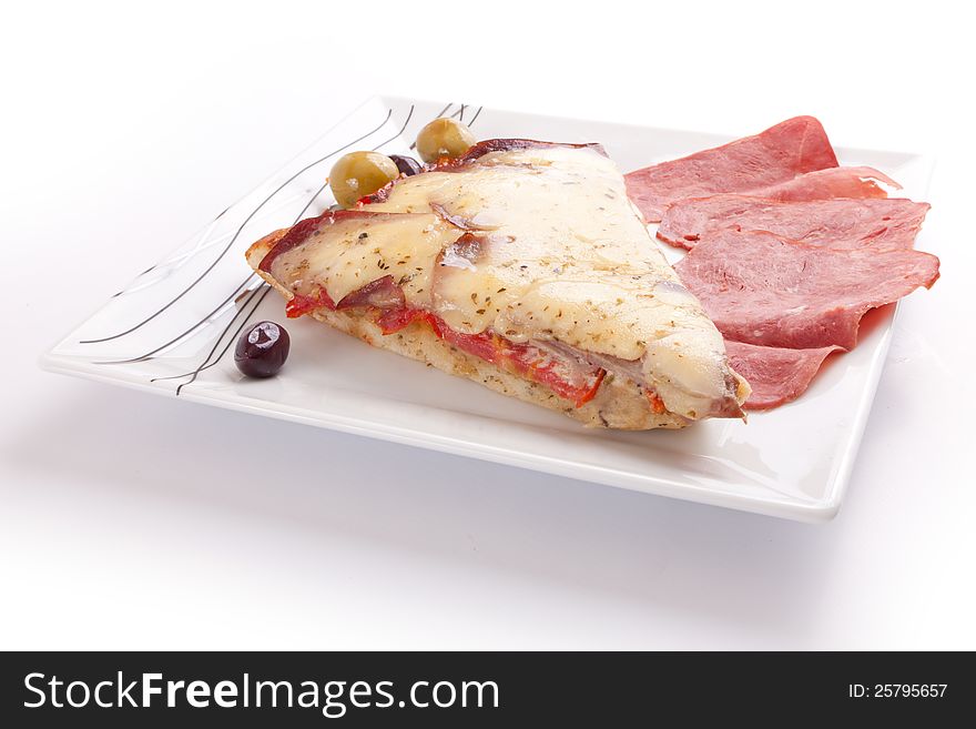 Pizza slice with olive and salami on a plate on white