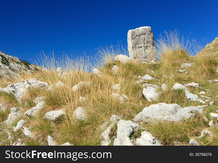 Old weather worn headstone on a mountain in Montenegro. Old weather worn headstone on a mountain in Montenegro