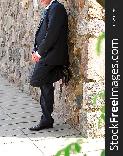 Lonely the man near a stone wall in city. Lonely the man near a stone wall in city