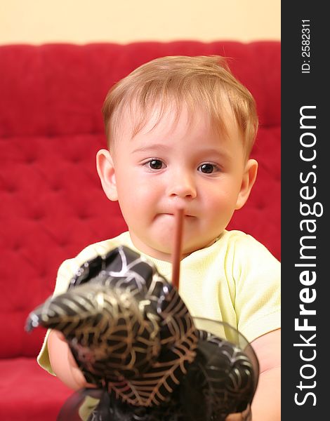 Little blond baby boy gesticulate while playing with wizard doll at home