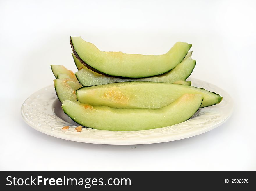 A plate of cut up mellon isolated on a white background. A plate of cut up mellon isolated on a white background.