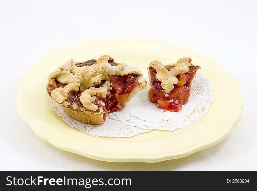 An individual cherry peach pie with lattice crust sliced and plated.