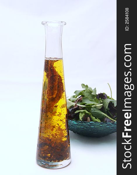 Oil bottle and healthy salad in  a white background. Oil bottle and healthy salad in  a white background