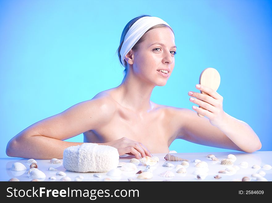 Young beautiful smiling woman with a bath sponge and a small mirror. Young beautiful smiling woman with a bath sponge and a small mirror