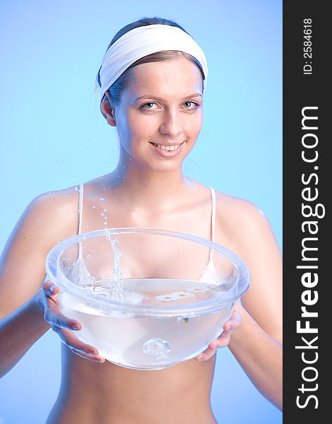 Young smiling woman is holding a bowl filled with water. Young smiling woman is holding a bowl filled with water