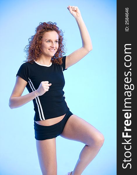 Young woman wearing a sporty outfit is doing exercises. Young woman wearing a sporty outfit is doing exercises