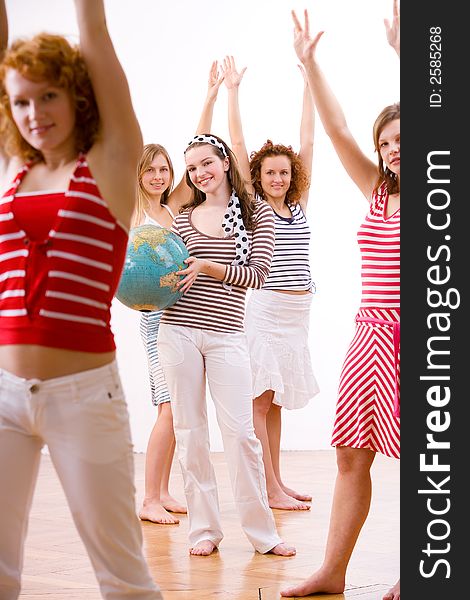 Five attractive young girls in summerclothes jubilating holding a globe. Five attractive young girls in summerclothes jubilating holding a globe