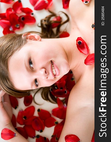 A young woman laying on tulip petals. A young woman laying on tulip petals