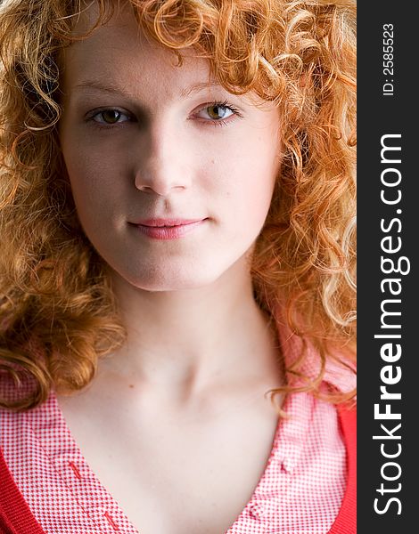 Portrait of a young red-haired woman looking straight into the camera. Portrait of a young red-haired woman looking straight into the camera