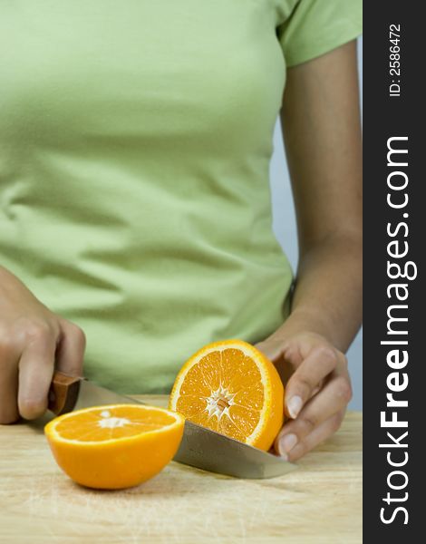 Girl cutting orange with knife