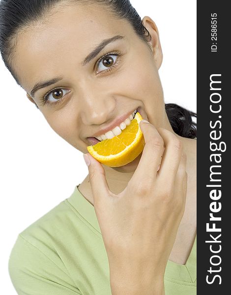 Smiling girl eating piece of orange. Smiling girl eating piece of orange