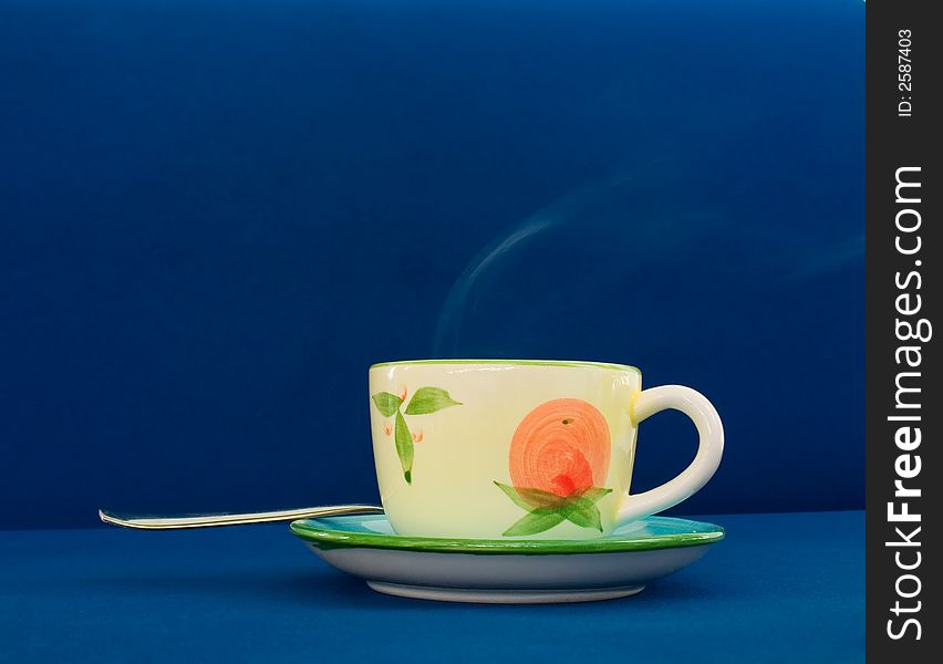 Steaming coffee cup on blue