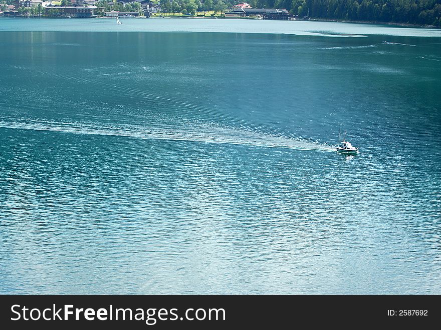 Motor boat is acrossing clear Alps lake. Motor boat is acrossing clear Alps lake