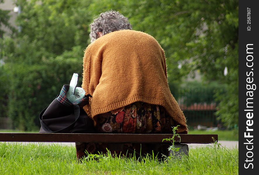 Older woman sitting on the bench in park, rest time. Older woman sitting on the bench in park, rest time...