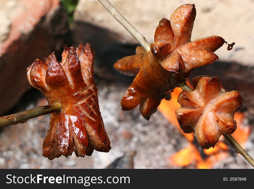 Baking of sausages on fire