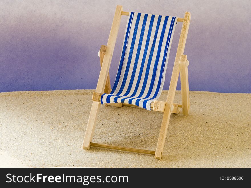 Blue white striped beach chair on the sand