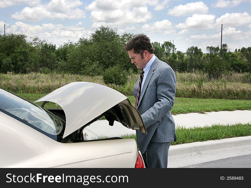A businessman on a road trip, opening his trunk. A businessman on a road trip, opening his trunk.