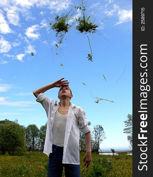 The boy throws a grass on a background of Baikal. The boy throws a grass on a background of Baikal