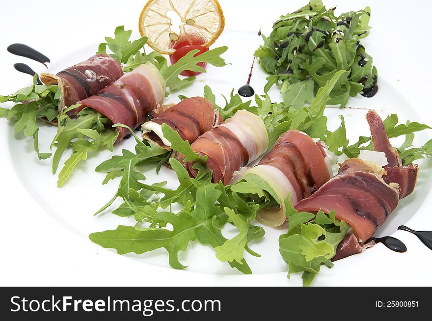 Rolls of meat and greens on a white background in the restaurant