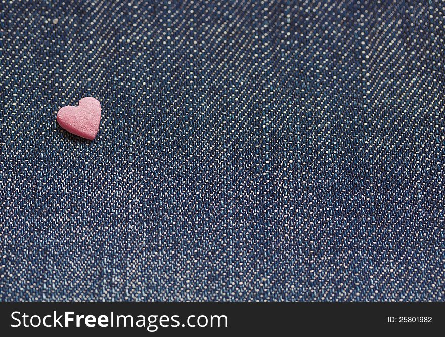 Jeans background with a little pink heart. Jeans background with a little pink heart