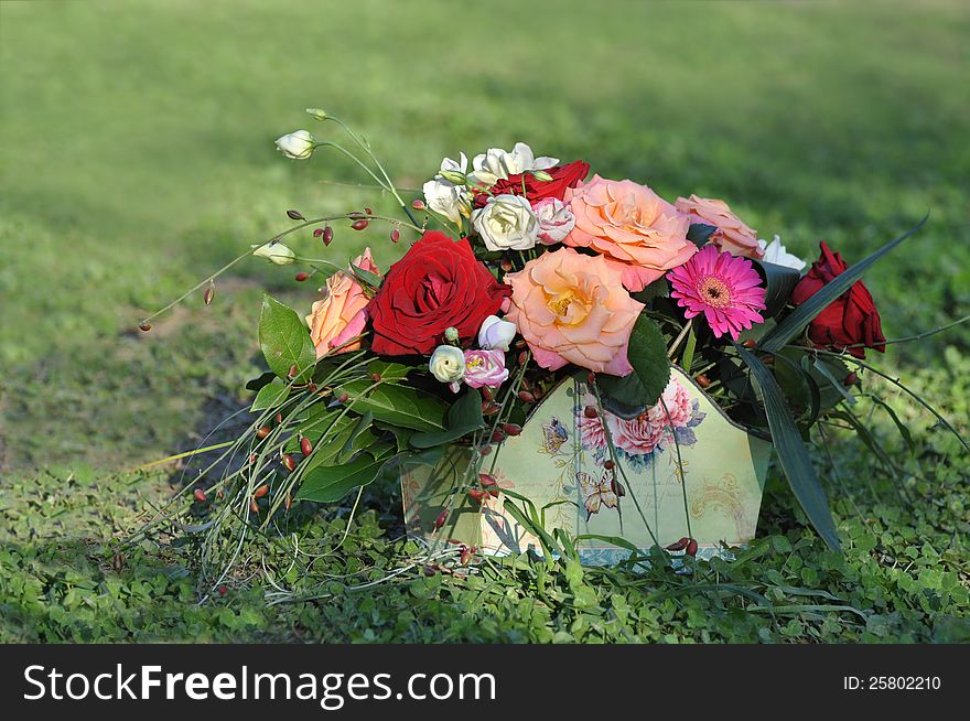 Basket with flowers against a green grass