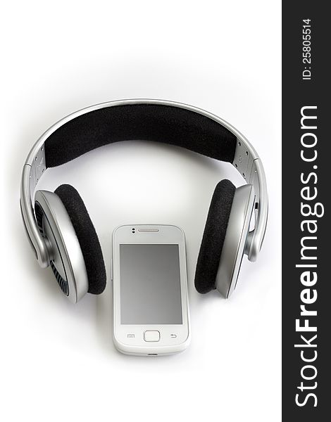 Wireless headphones and a white mobile phone. Wireless headphones and a white mobile phone.