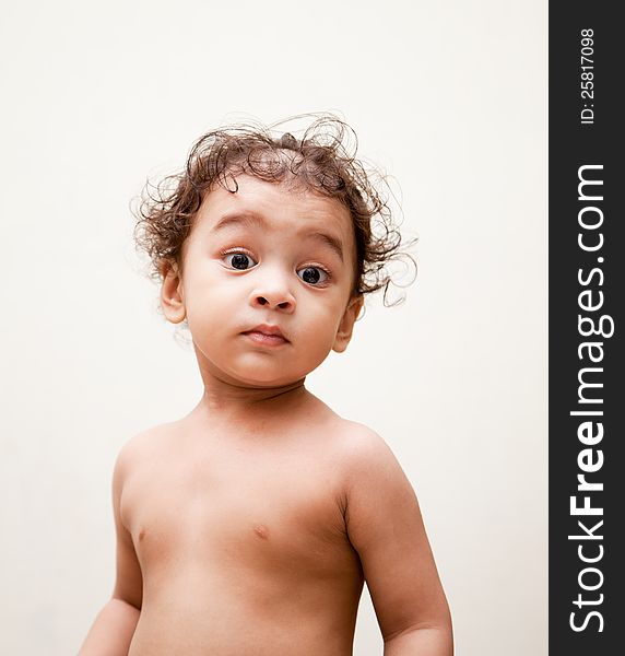 Surprised indian baby boy over white background