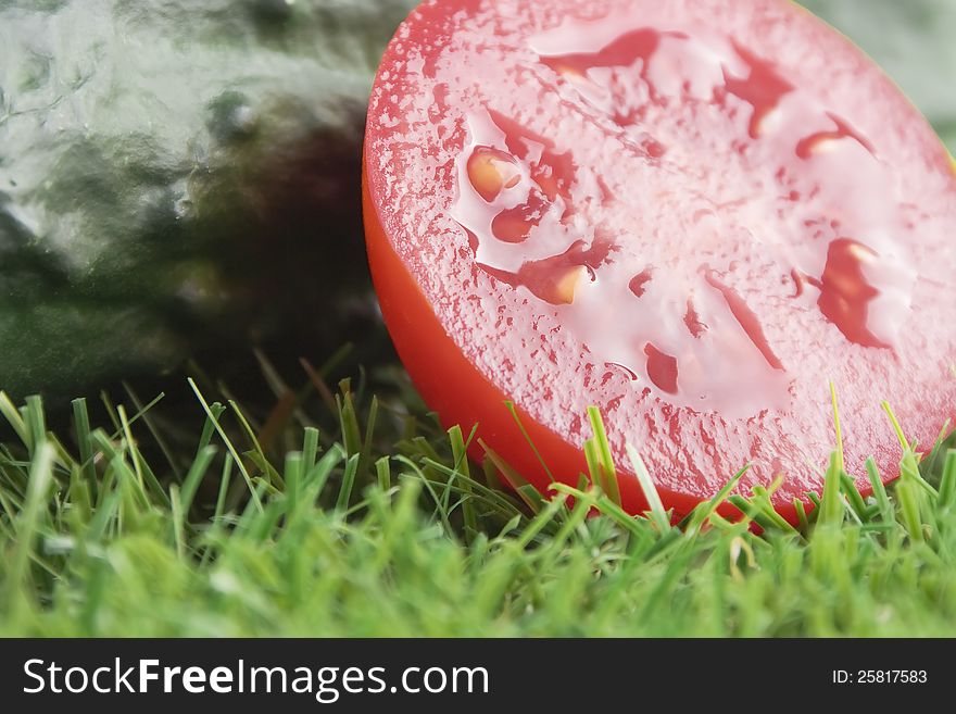 Close up of half a tomato with cucumber at the bottom