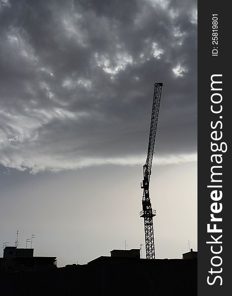 Crane silhouette over a dramatic sky with clouds