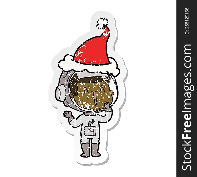 laughing hand drawn distressed sticker cartoon of a astronaut wearing santa hat