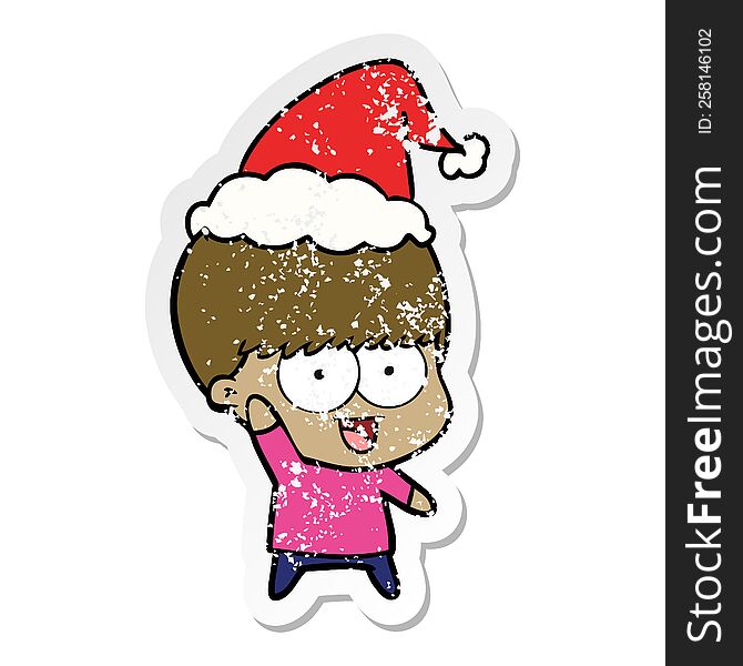 happy hand drawn distressed sticker cartoon of a boy waving wearing santa hat