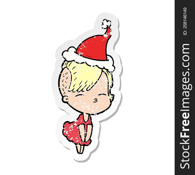 Distressed Sticker Cartoon Of A Squinting Girl In Dress Wearing Santa Hat